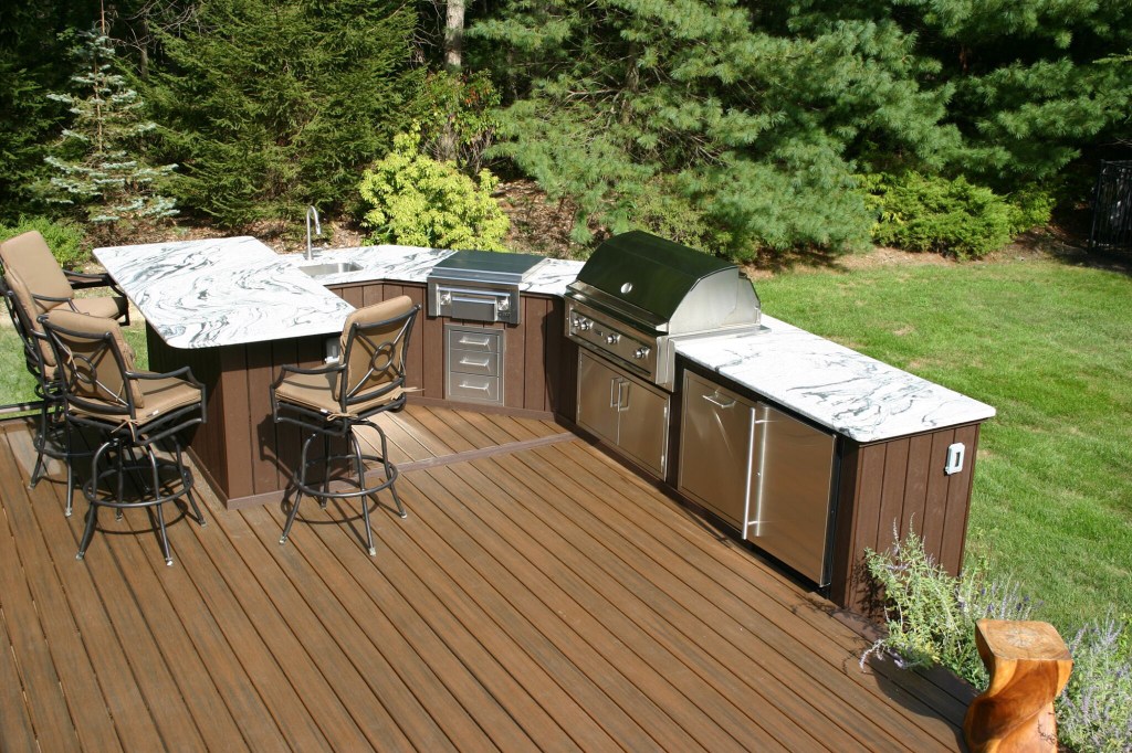 Clarksburg

 This outdoor space is a homeowners dream! With so much to do, the homeowners and their guests can enjoy this deck space for hours at a time. Completed in April of this year, the deck itself is constructed with composite decking. The glass railing infill provides an illusion that that deck never ends. The deck features several different living areas. The aluminum shade structure provides protection from the sun and elements. Granite countertops and stone veneer accent the top of the line stainless steel appliances. 
        On cool summer nights, the homeowners can cozy up next to the custom fireplace, which is surrounded with plenty of seating. It is easy to relax in this outdoor space as this deck also features a built in spa.